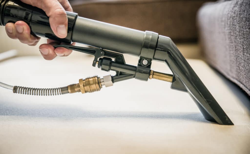 Cleaning,Couch,With,Steam,Cleaner